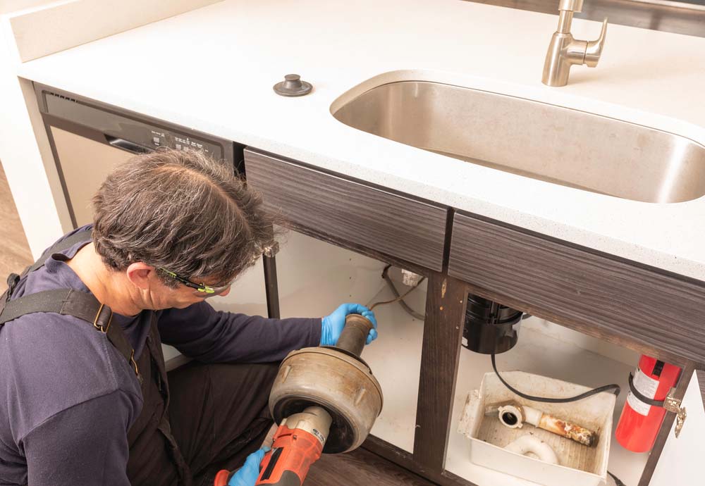 Plumber cleaning a drain using an auger Twin Falls, ID