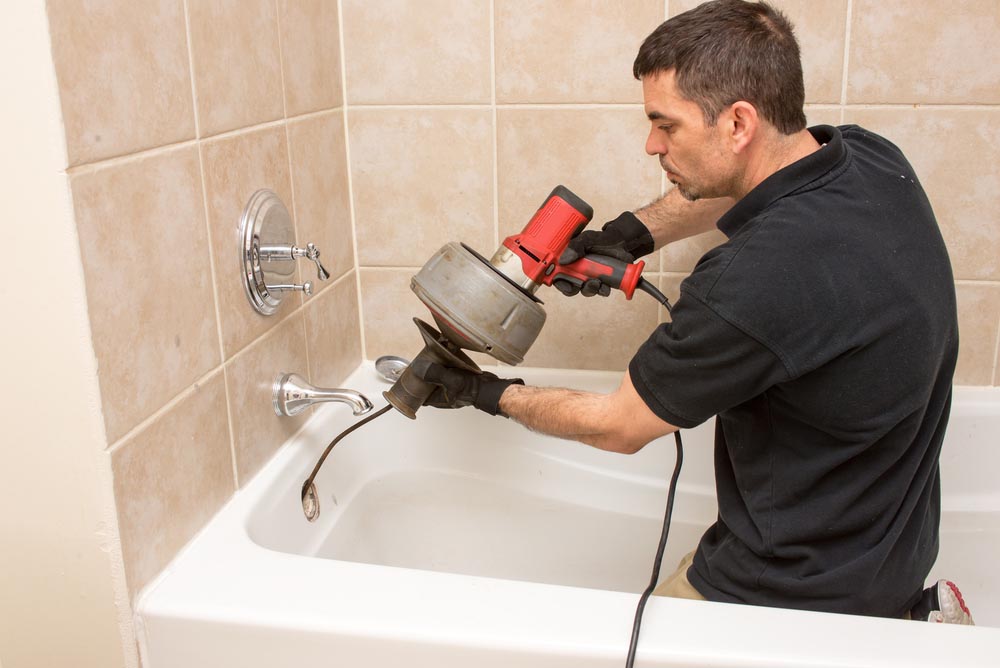 person holding a drain snake